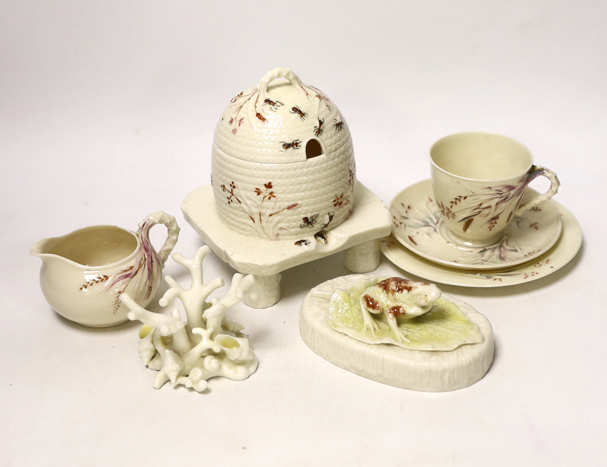 A small quantity of 1st and 2nd period Belleek including a ‘frog’ paperweight and a ‘beehive’ honey jar together with a related reference book by Marion Langham